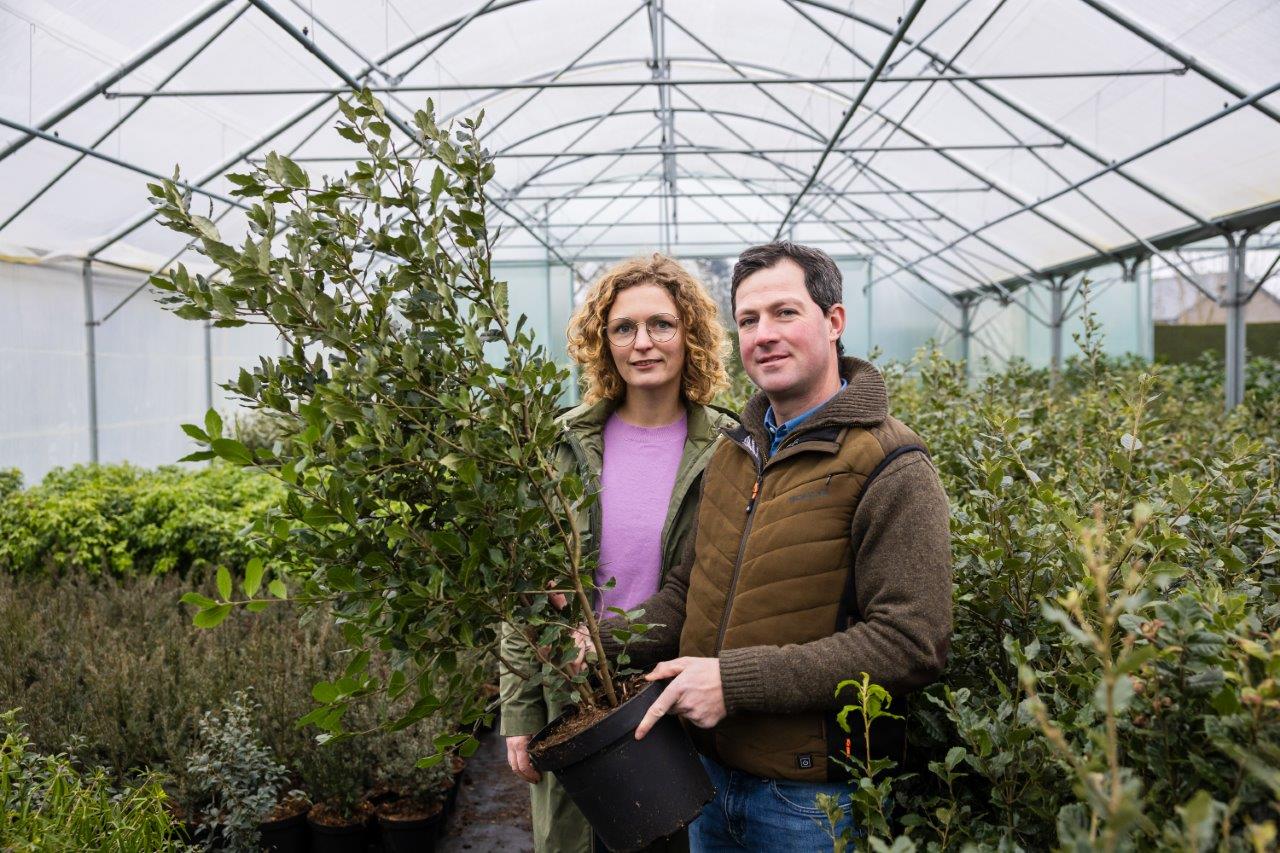 Bert en Lien in de serre met een plant in de handen